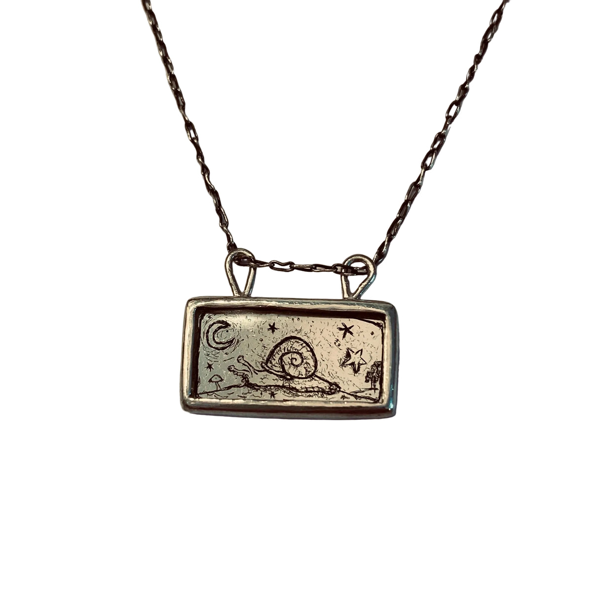 Silver necklace with a rectangular pendant featuring a snail design etched into gold leaf
